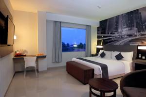 a hotel room with a bed and a large window at Hotel Neo Candi Simpang Lima - Semarang by ASTON in Semarang