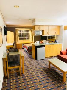 a hotel room with a kitchen and a bedroom at Ramada Limited and Suites Bloomington in Bloomington