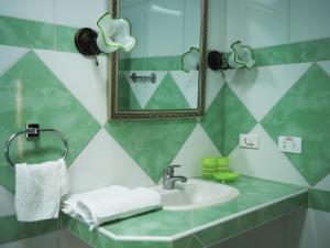 a bathroom with a sink and a mirror at Xanadú B & B in Holguín