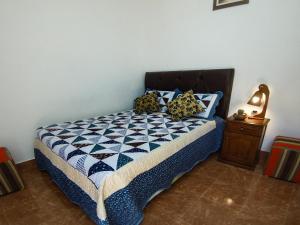 a bedroom with a bed with a blue and white quilt at Tilcara Hostal Niña Coya in Tilcara