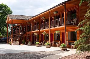 a log cabin with chairs and a staircase in front of it at Austin's Chuckwagon Motel in Torrey