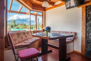 a dining room with a table and a bench and a window at Martina Bungalows in La Ensenada