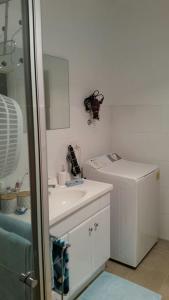 a white bathroom with a sink and a mirror at Self-contained Private 2 Bedroom Apartment in Macgregor