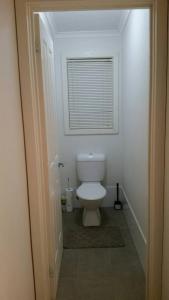 a bathroom with a toilet with a window in it at Self-contained Private 2 Bedroom Apartment in Macgregor