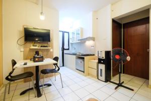 a kitchen with a table and chairs in a room at Homey and Simply 2BR Kebagusan City Apartment By Travelio in Jakarta