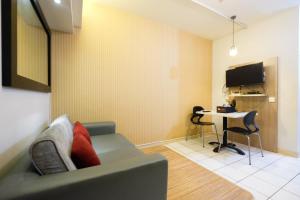 a living room with a couch and a desk at Homey and Simply 2BR Kebagusan City Apartment By Travelio in Jakarta