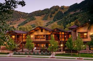 una casa de madera con montañas en el fondo en Innsbruck Aspen Deluxe One-Bedroom Garden Residence 03 w/ Hot tub, Centrally located, en Aspen
