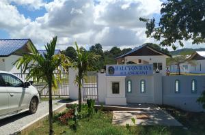 une voiture blanche garée devant un bâtiment dans l'établissement Halcyon Days @ Langkawi, à Pantai Cenang