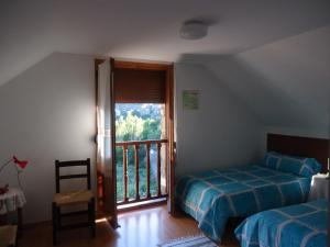 a bedroom with a bed and a window with a balcony at Casa Úrsula in Ansó