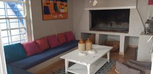 a living room with a blue couch and a table at Pondok in Paternoster