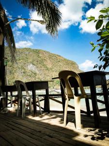 a table and chairs on a deck with a view of a mountain at Joyful Guest House in El Nido