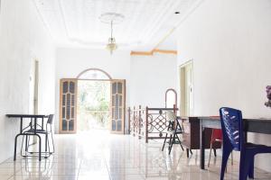RedDoorz near Sultan Hasanuddin Airport 2 في ماكاسار: غرفة بيضاء فيها طاولة وكراسي