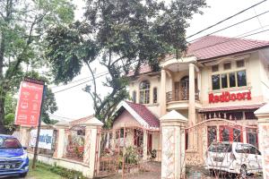 a house with a sign in front of it at RedDoorz near Sultan Hasanuddin Airport 2 in Makassar