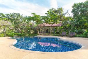 a swimming pool in front of a house at Panalee Koh Samui Resort - SHA Plus in Ban Bang Po