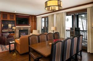 una sala da pranzo con tavolo e sedie e un soggiorno di The Ritz-Carlton Club, 3 Bedroom Residence WR 2312, Ski-in & Ski-out Resort in Aspen Highlands ad Aspen