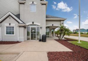 a large white house with a driveway at Studio 6-Ingleside, TX in Ingleside