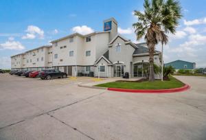 a large white building with cars parked in a parking lot at Studio 6-Ingleside, TX in Ingleside