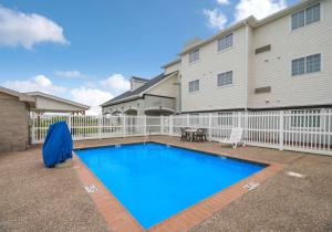 a swimming pool in front of a house at Studio 6-Ingleside, TX in Ingleside