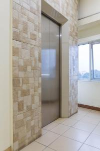 a door in a room with a stone wall at RedDoorz Plus @ Surapati 2 in Bandung