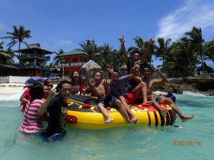 a group of people sitting on a raft in the water at Anda Poseidon’s Beach Resort in Anda