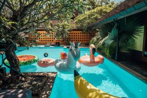 a swimming pool with a raft and inflatables in a backyard at Chandra Residence in Chiang Mai
