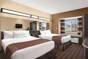 um quarto de hotel com duas camas e uma televisão em Microtel Inn & Suites-Sayre, PA em Sayre