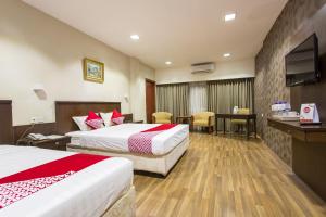 Cette chambre comprend 2 lits et une télévision à écran plat. dans l'établissement Capital O 769 City Hotel, à Balikpapan