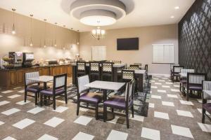 a dining room with tables and chairs and a kitchen at La Quinta by Wyndham Dallas South-DeSoto in DeSoto