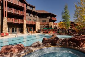 a swimming pool in front of a hotel at The Ritz-Carlton Club, 3 Bedroom Residence 8106, Ski-in & Ski-out Resort in Aspen Highlands in Aspen
