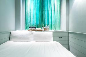 uma cama num quarto com uma cortina verde em Fun Simon em Tainan