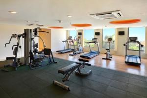 a gym with several treadmills and elliptical machines at HARRIS Hotel Seminyak in Seminyak