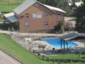 a building with a swimming pool next to a house at Black Hills Cabins at Quail's Crossing in Hill City