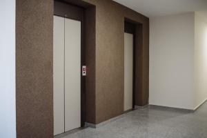 una fila de tres ascensores en un edificio en Jacuzzi Room, en Subotica