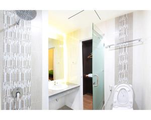 2 fotos de un baño con aseo y lavabo en Emerald Hotel, en Ternate