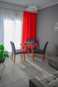 een woonkamer met een tafel en stoelen en een rood gordijn bij Appartment Anna in Mastichari