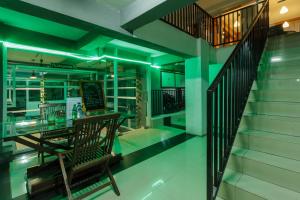 een kamer met een tafel en een trap met groene verlichting bij RedDoorz Premium @ Ampera Raya 2 in Jakarta