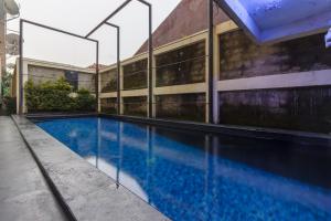 a swimming pool in front of a building at RedDoorz Premium @ Ampera Raya 2 in Jakarta