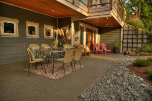 a patio with a table and chairs on a house at Shawnigan Suite B & B in Shawnigan Lake