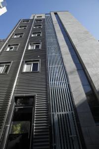 ソウルにあるThe Core Albergueの多くの窓がある高い黒い建物