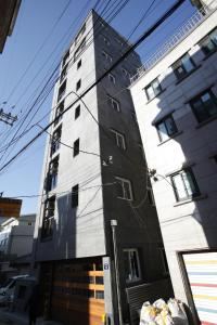 a tall white building on a city street at The Core Albergue in Seoul