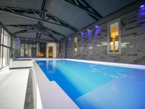 a large swimming pool in a building at Le Magic Hôtel & Spa - Centre Historique - Climatisation - Parking - Bornes de recharge in Vitré