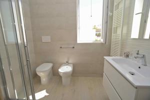 een witte badkamer met een toilet en een wastafel bij Altomare Case Vacanza in Porto Cesareo