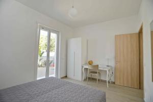 een witte slaapkamer met een bed en een bureau bij Altomare Case Vacanza in Porto Cesareo