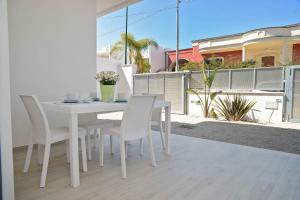 een witte eettafel en stoelen op een balkon bij Altomare Case Vacanza in Porto Cesareo +15 foto's