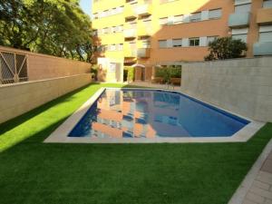 a swimming pool in a yard next to a building at Apartamentos City Beach in Barcelona