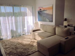 een woonkamer met een bank en een groot raam bij Cavalo Preto Luxury Beach Resort - C201 in Quarteira