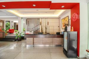 a kitchen with a refrigerator and a red wall at Super OYO Collection O Sweet Karina Bandung in Bandung