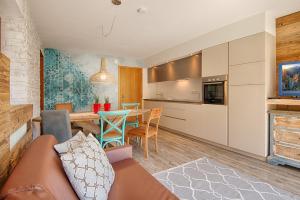 eine Küche und ein Wohnzimmer mit einem Sofa und einem Tisch in der Unterkunft Residence Alpenrose in St. Johann im Ahrntal