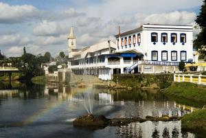 a building with a rainbow in the middle of a river at Nhundiaquara Hotel e Restaurante in Morretes