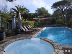 einen Pool in einem Garten mit zwei Liegestühlen in der Unterkunft Chambres d'Hôtes Les Mayombes in Roquebrune-sur-Argens